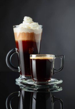 Siyah yansıtıcı arka planda çeşitli kahve içiyor. Espresso ve İrlandalı kahve Cam bardaklar.