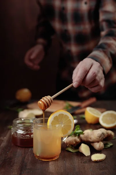 Cup of ginger tea with honey , lemon and mint on old wooden table .  Selective focus .