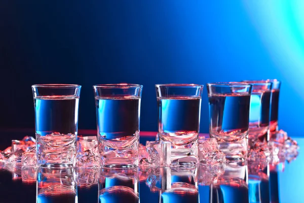 Wodkagläser Mit Eis Auf Einem Glastisch Rotes Und Blaues Licht — Stockfoto