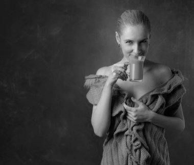 Yakın çekim portre orta yaş kadın güzel bir fincan kahve ile. Çekici ve mutlu sarışın çıplak omuz ile süveterli sütlü kahve içer. Uzay kopyalayın. Siyah ve beyaz.