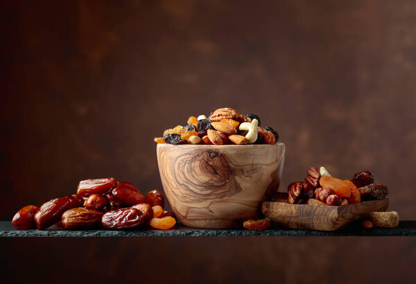 Various dried fruits and nuts in wooden dish. Copy space.