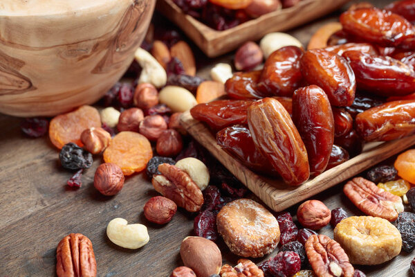 Various dried fruits and nuts on a old wooden table.