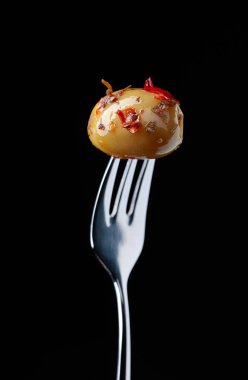 Baharatlı yeşil zeytin yağı çatal üzerinde.