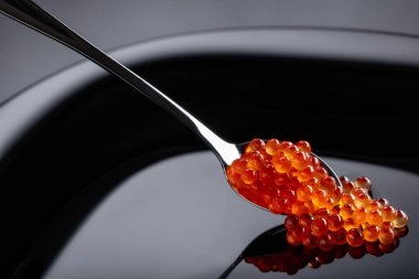  Siyah bir tabak kaşık kırmızı havyar.