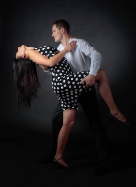 Puantiyeli elbise ve tango dans Beyaz tişörtlü adam güzel bir kadın. Kaç stüdyoda dans aşk içinde.