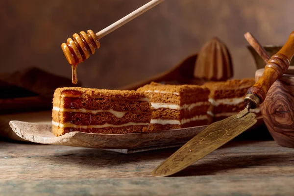 自制分层蜂蜜蛋糕与奶油在一个旧的木桌 — 图库照片