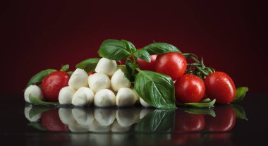 Mozzarella fesleğen ve siyah bir tabloda domates ile.
