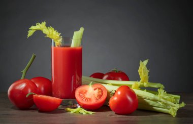 Domates suyu domates ve kereviz ile ahşap bir masa üzerinde sopa. Metniniz için kopya alanı.