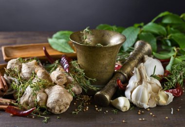 Farklı otlar ve baharatlar ahşap bir masa üzerinde. Eski bakır havan topu baharat .