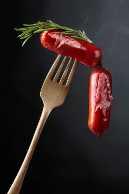 Izgara sosis ve çatalla biberiye. Siyah arkaplan, boşluğu kopyala. 