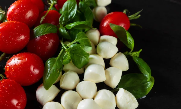 Mozzarella Con Albahaca Tomates Sobre Una Mesa Negra —  Fotos de Stock
