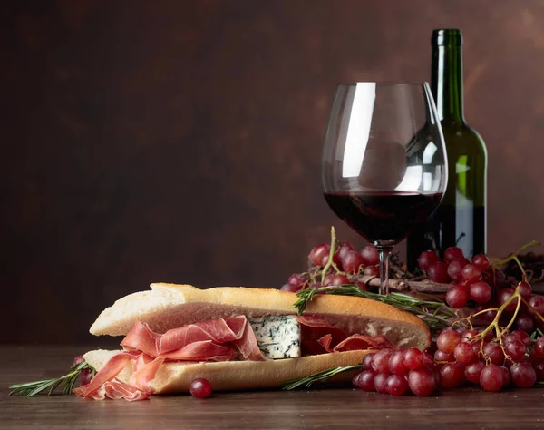 黒を背景にプロシュート ブルーチーズ ローズマリーをサンド おいしいスナックと赤ワイン テキストのスペースをコピー — ストック写真