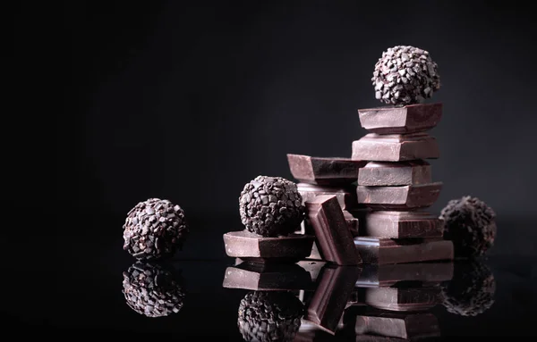 Caramelle Cioccolato Con Pezzi Cioccolato Rotti Sfondo Nero Riflettente Copia — Foto Stock