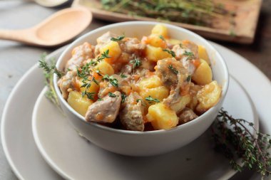  İrlanda güveci ile yeşil kekik serpilir. Patates, havuç ve baharat ahşap arka plan üzerinde demlenmiş et. 