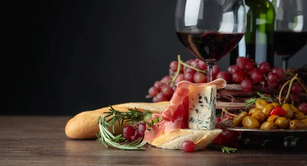 夹杂着意大利火腿 蓝奶酪和迷迭香的三明治 背景是深色的 美味的小吃和红酒复制您的文本空间 — 图库照片