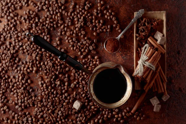 Coffee in an old copper coffee maker with cinnamon, anise and pieces of brown sugar. View from the top.