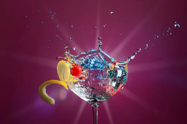 Colorful Cocktail Glass Splashes Garnished Lemon Cherries Purple Background Mixed — Stock Photo, Image