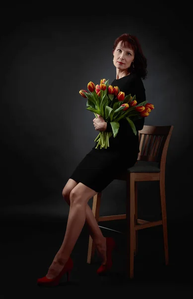 Mujer atractiva con un ramo de tulipanes rojos y amarillos . —  Fotos de Stock