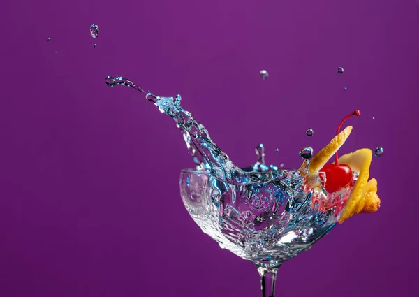 Cocktail en verre avec éclaboussures garnies de citron et de cerise — Photo