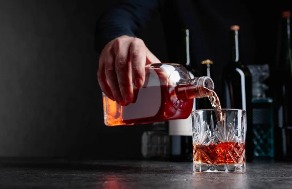 Man pours whiskey in a glass at the bar. — Stock Photo, Image