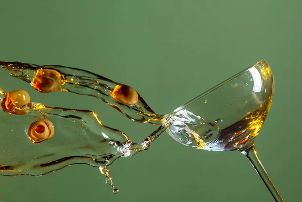 Suché martini s zelenými olivami na zeleném pozadí. — Stock fotografie