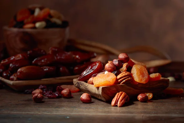 Různé sušené ovoce a oříšky v dřevěné misce. — Stock fotografie