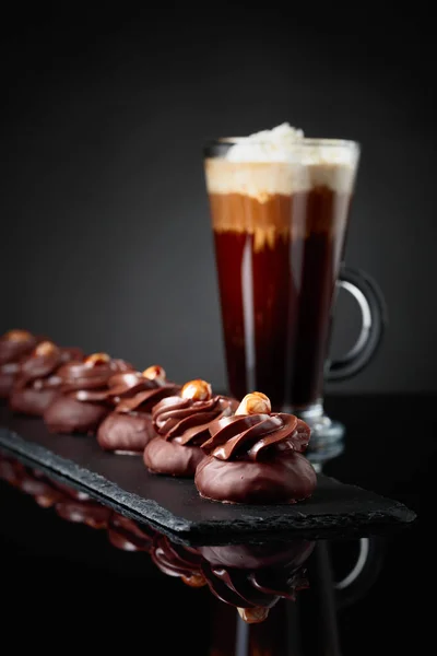 Chocolate dessert with hazelnut and coffee with cream on a blac — Stock Photo, Image