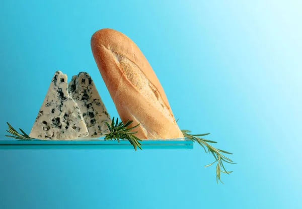 Queso azul con pan y romero sobre fondo azul . —  Fotos de Stock