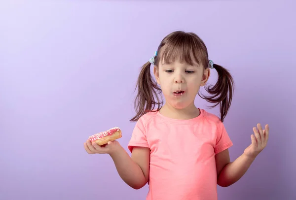 Four-year-old girl eat donut. — Stock Photo, Image