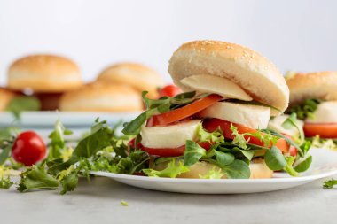 Mozzarella peyniri, domates, salata mutfak masasında ile sandviç.