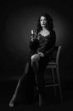 Portre çekici esmer bardak brendi bir siyah ile 