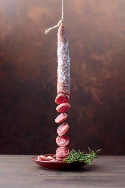 Dry-cured sausage with rosemary. clipart