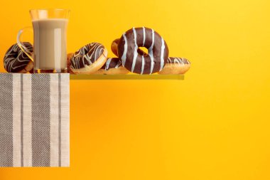 Çikolatalı çörek ve latte siyah bir zemin üzerine. 