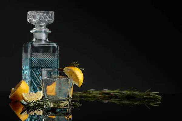 Cocktail gin, tonique avec des tranches de citron et un brin de romarin — Photo