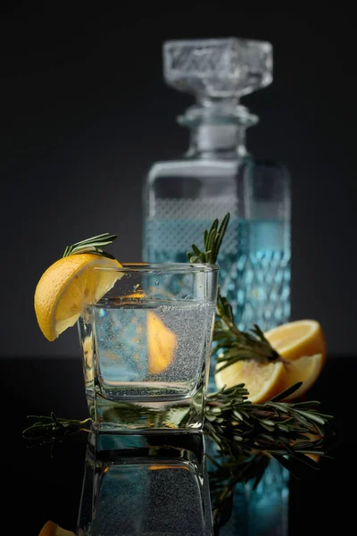 Kokteyl cin, limon dilimleri ile tonik ve bir ince dal biberiye. — Stok fotoğraf