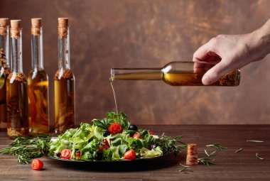 Dökme küçük bir şişe zeytinyağı ile yeşil salata. 