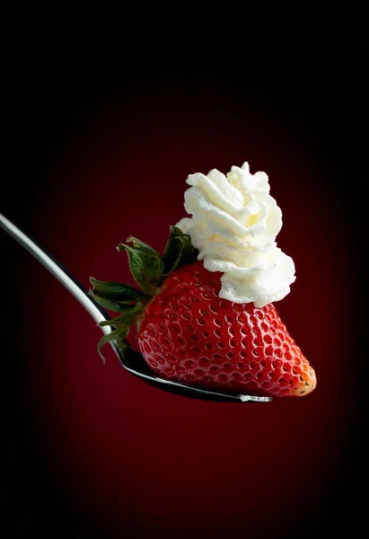 Strawberry with whipped cream on a dark background. — Stock Photo, Image