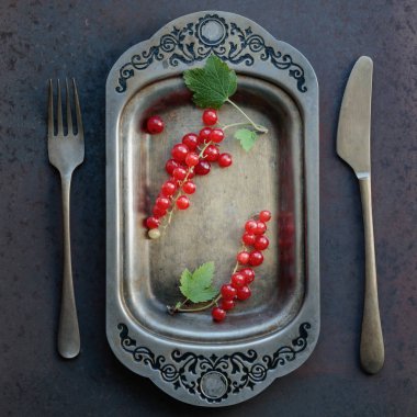 Redcurrants metal çanak çatal ve bıçak üzerinde. 