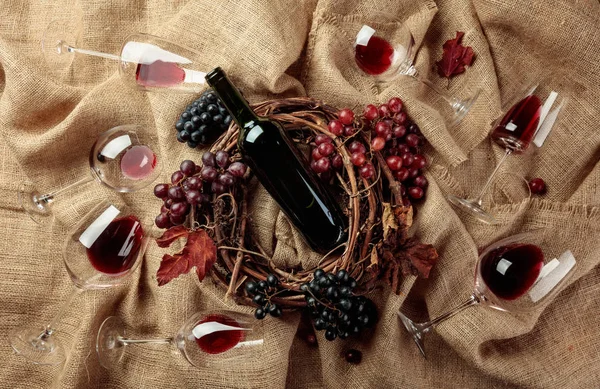Rode wijn en druiven op een jute. — Stockfoto