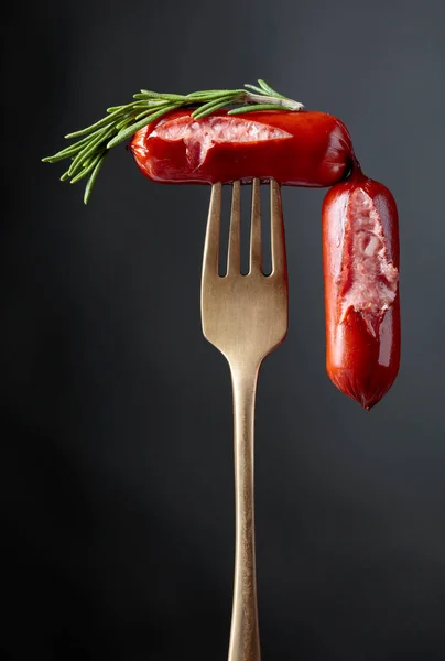 Salsichas grelhadas com alecrim em um garfo. — Fotografia de Stock