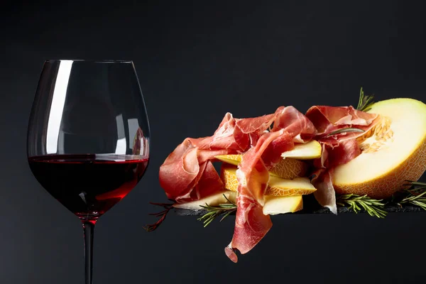 Red wine with prosciutto and melon. — Stock Photo, Image