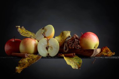 Sulu elma ve tarçın siyah bir zemin üzerine.