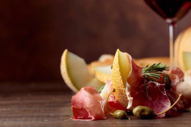  Jambon kavun, Kapari ve biberiye üzerinde eski bir ahşap tabl