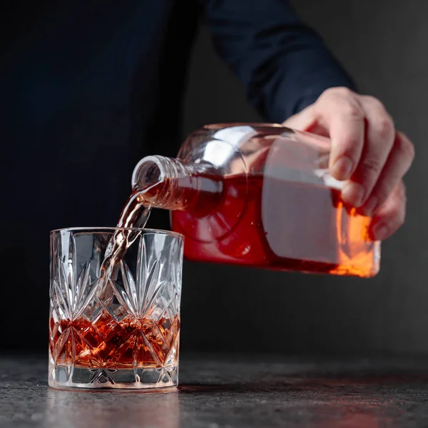 Man häller whiskey i ett glas. — Stockfoto