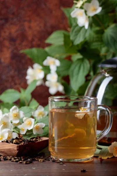 Chá verde com jasmim na xícara e bule na mesa de madeira . — Fotografia de Stock