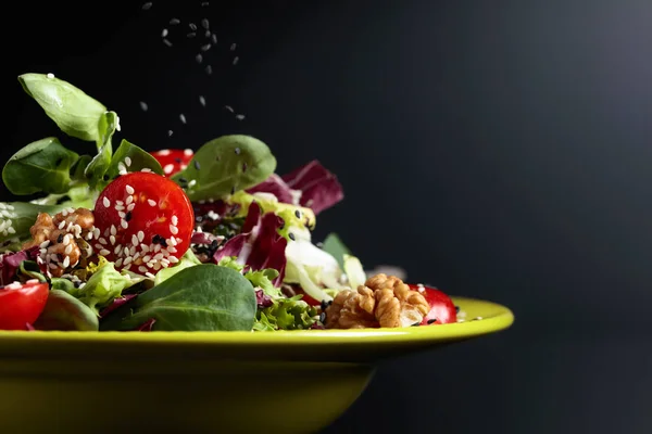 Зеленый салат с помидорами черри, кунжутом, орехами и овощами — стоковое фото