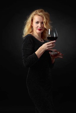 Kırmızı şarap cam ile Siyah Abiye elbise çekici kadın.