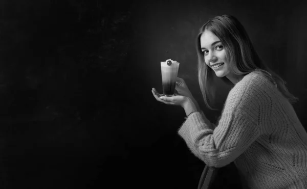 Красивая блондинка в свитере держит кружку кофе со сливками — стоковое фото