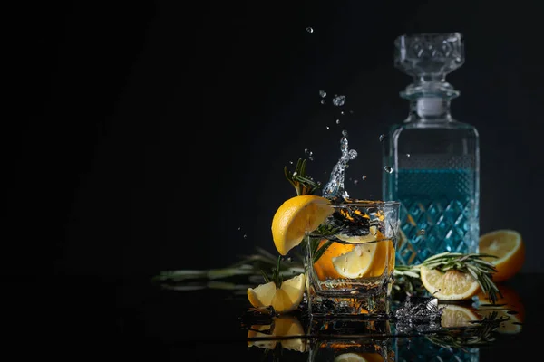 Cocktail gin-tonic med citronskivor och kvistar rosmarin. — Stockfoto
