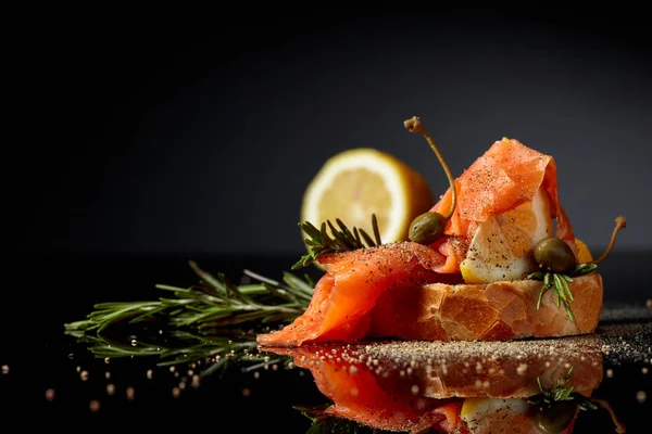 Sandwich with trout fillet, lemon slice, capers and rosemary spr — Stock Photo, Image